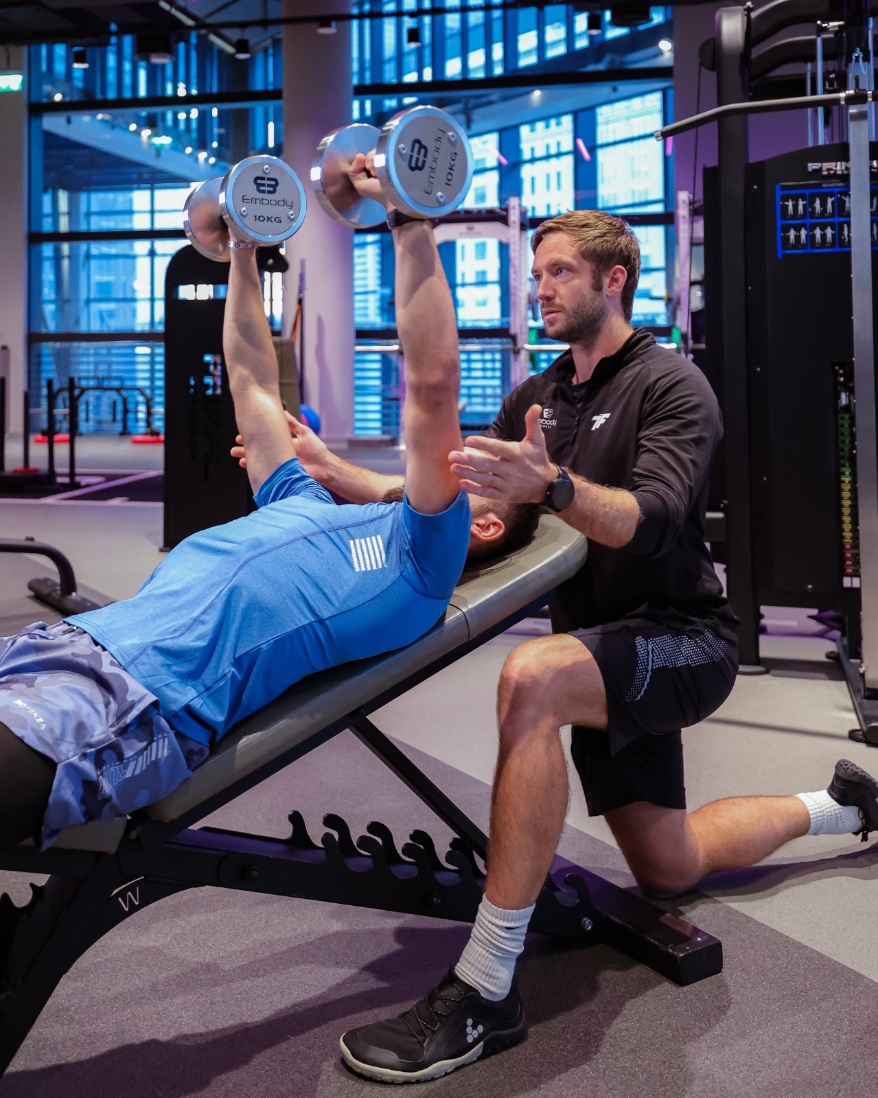 man spotting man doing dumbbell press