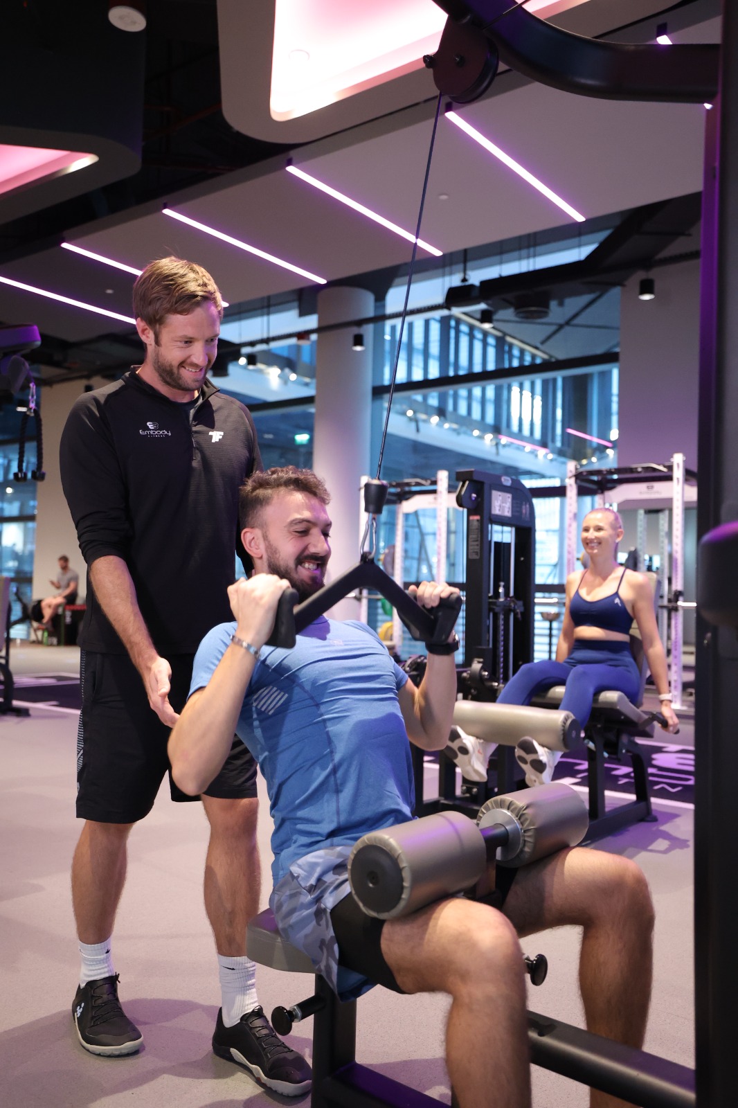 trainer training member doing lat pull down